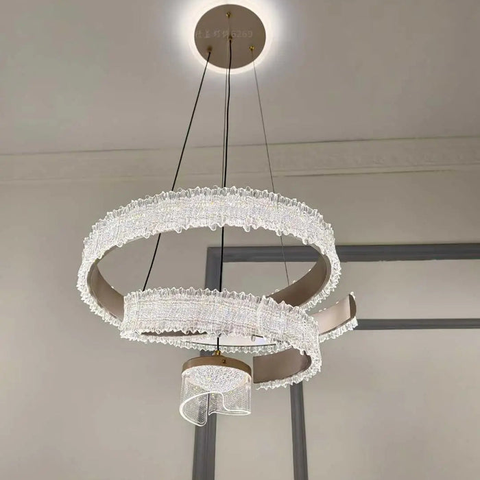 Modern chandelier with three circular designs hanging from the ceiling.