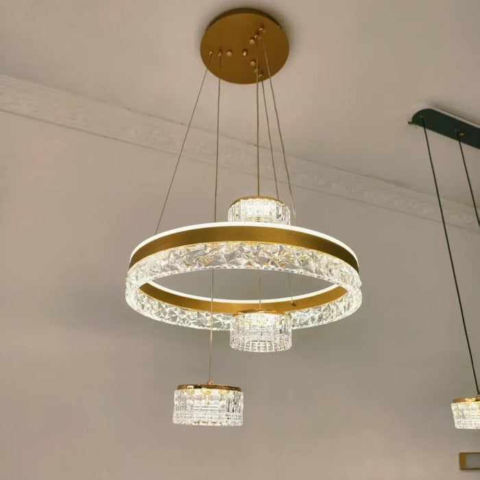 Modern chandelier with gold accents and crystal elements hanging from a ceiling.