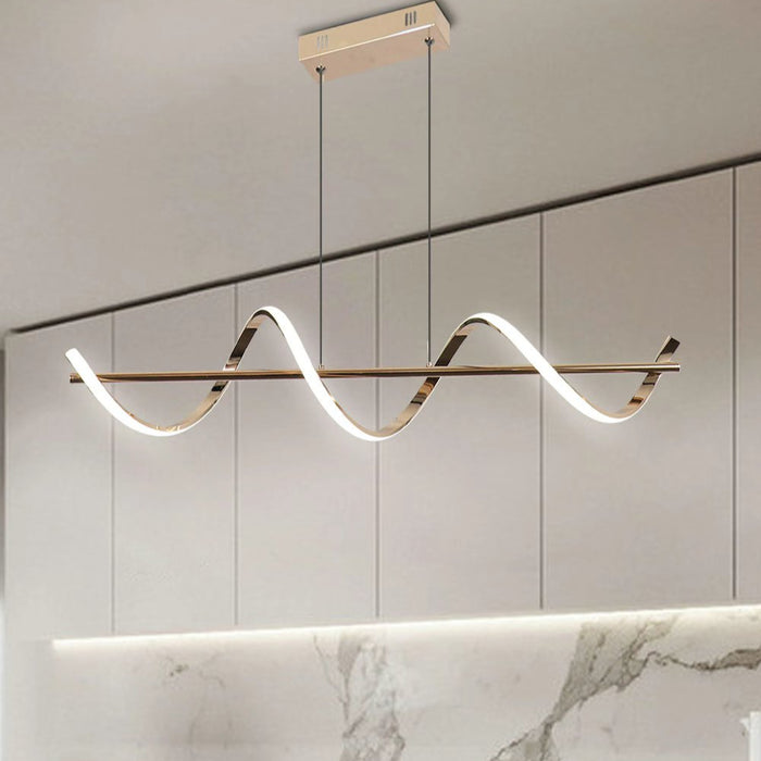 Modern pendant light fixture hanging above a dining table with marble backsplash.