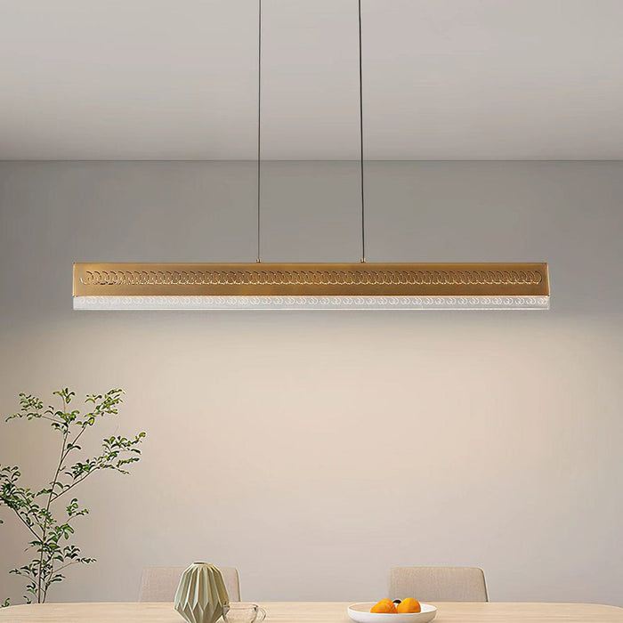 Modern dining area with a long rectangular table and gray chairs, featuring a pendant light.