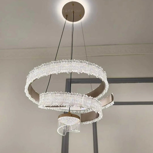 Modern chandelier with three circular designs hanging from the ceiling.