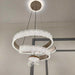 Modern chandelier with three circular designs hanging from the ceiling.