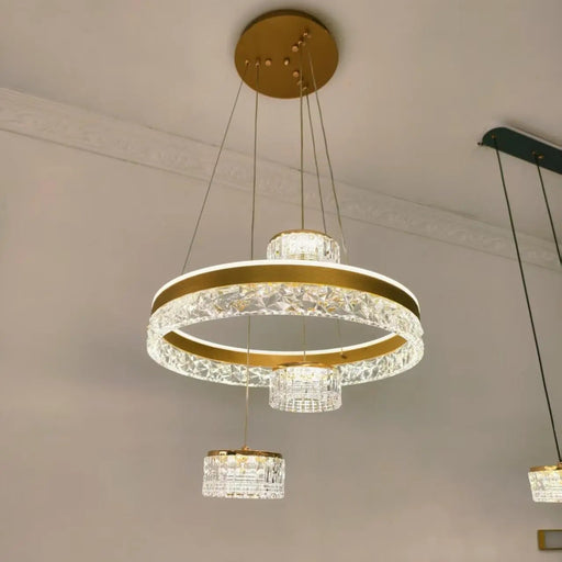 Modern chandelier with gold accents and crystal elements hanging from a ceiling.
