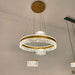 Modern chandelier with gold accents and crystal elements hanging from a ceiling.
