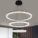 Modern chandelier with three circular lights in a living room setting.