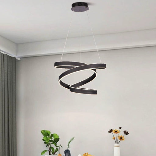 Modern dining room with a black spiral pendant light, round table, and gray chairs.