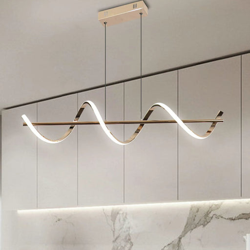 Modern pendant light fixture hanging above a dining table with marble backsplash.