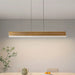 Modern dining area with a long rectangular table and gray chairs, featuring a pendant light.
